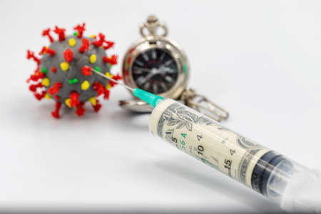 A syringe with a dose of dollars is injected into a coronavirus model to defeat the disease