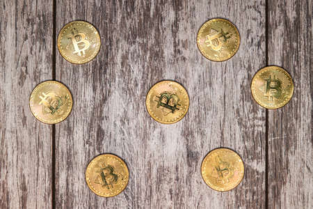 Large gold coins bitcoin lie on a light wooden surface
