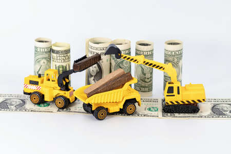 Toy construction equipment harvests wood and loads it on a truckの写真素材