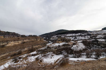Mountain river flows through a deep snow-covered canyon in the Caucasusの写真素材