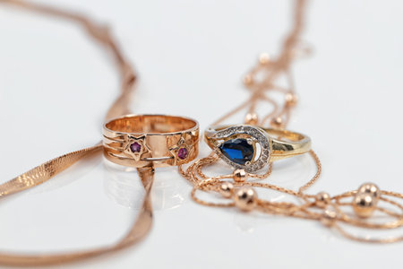 Two different-shaped gold rings with precious stones and two completely different-shaped gold chainsの写真素材