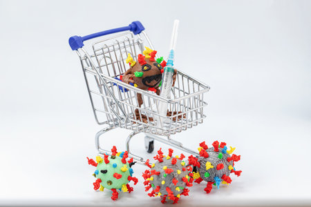 Monster virus holds a syringe while standing in a grocery cart surrounded by other virusesの写真素材