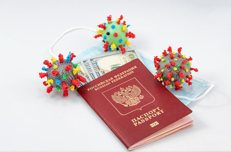 Protective medical masks, dollars, a passport and a 3D models of the virus lie nearbyの写真素材