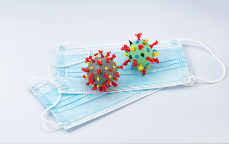 A 3D model of a virus cell made with a 3D pen is placed on top of a protective medical maskの写真素材