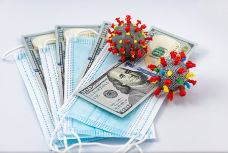 Protective disposable breathing masks, hundred-dollar bills, and a 3D model of the coronavirusの写真素材