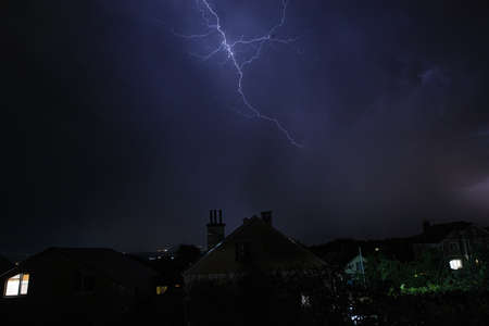 A flash of lightning against the evening sky and mountain rangesの写真素材