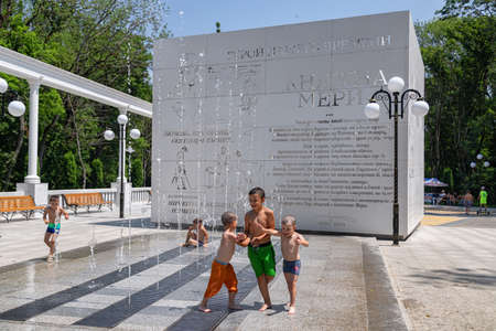 ZHELEZNOVODSK - JULY 04: Children escape from the scorching summer sun in the streams of the city fountain. July 04, 2021 in Zheleznovodsk, Russia.のeditorial素材
