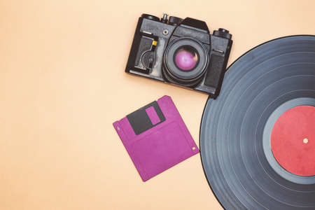 An old vinyl record, a film camera and a floppy disk for a computer are reminder of the rapid progress in the field of high technologiesの写真素材