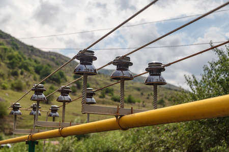 A small power line is laid directly through a gas pipe leading to a mountain villageの写真素材