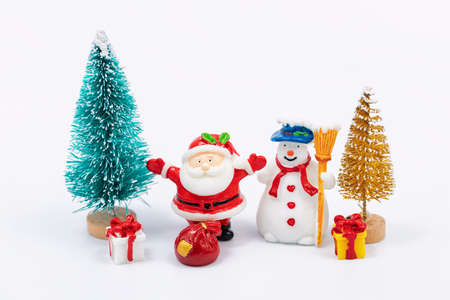 Toy Santa Claus and snowman put gifts under the toy Christmas tree