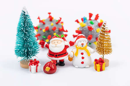 Snowman, Santa Claus, Christmas tree and gifts on the background of the coronavirus modelの写真素材