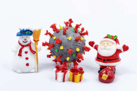 Snowman, Santa Claus, Christmas tree and gifts on the background of the coronavirus modelの写真素材