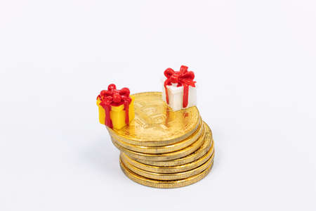 Toy gift boxes stand on a stack of bitcoin coinsの写真素材