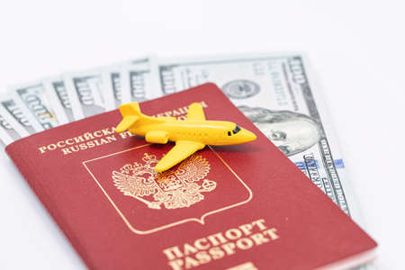 Toy model airplane lies on the passport of the Russian Federation with dollars insideの写真素材