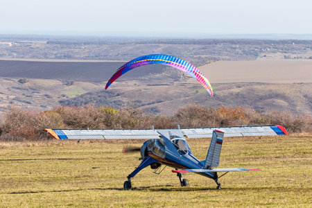 A small light-engine aircraft stands on a field airfield preparing for takeoffの写真素材