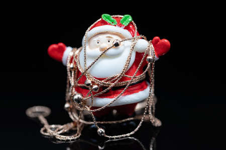 Toy Santa Claus is wrapped in a thin female gold chainの写真素材