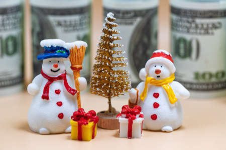 Toy figures of snowmen, Christmas tree, gifts and dollarsの写真素材