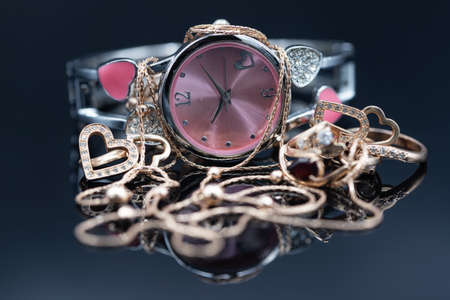 Elegant gold womens jewelry and watch with pink dialの写真素材