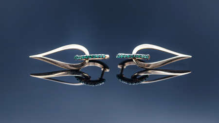 Gold earrings in the shape of a drop with emerald insertsの写真素材
