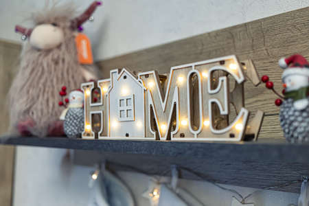 Decoration of the interior of the living room with a shelf with decorative wooden inscription HOMEの写真素材