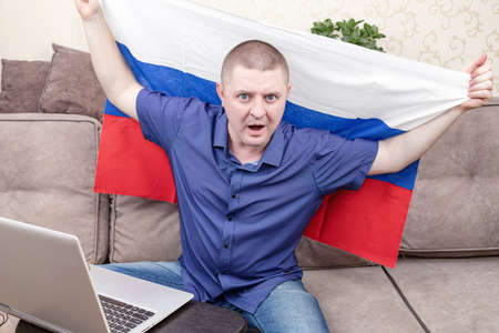 A fan of the Russian national team with a flag supports his team liveの写真素材
