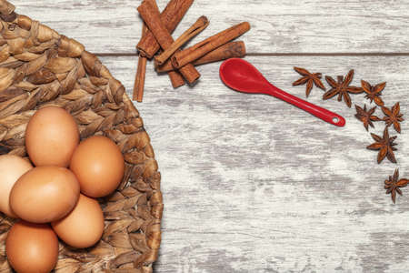 Background with spices, garlic, anise and chicken eggs in a wicker basket