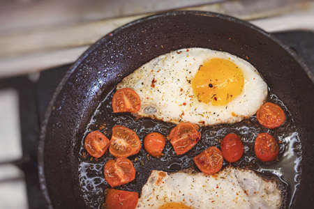 scrambled eggs with spices and small red tomatoesの写真素材