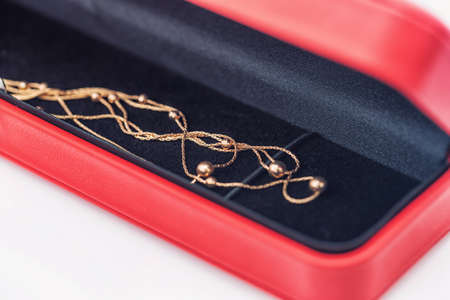 An elegant gold chain lies inside gift boxの写真素材