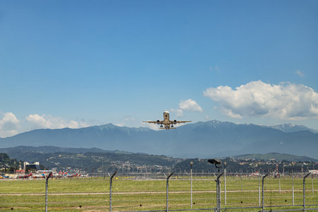 Take-off of a passenger plane from Adler airport against the background of a mountain range and cloudsのeditorial素材