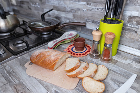 Sliced bread lies on a cutting board on kitchen table