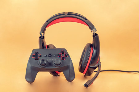 Background of the necessary accessories for the gamer: joystick and headphones with microphoneの写真素材