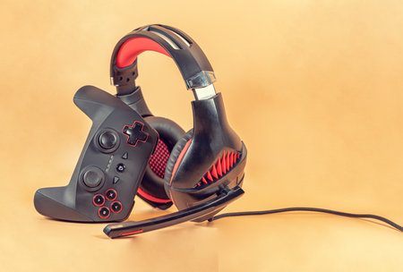 Background of the necessary accessories for the gamer: joystick and headphones with microphoneの写真素材