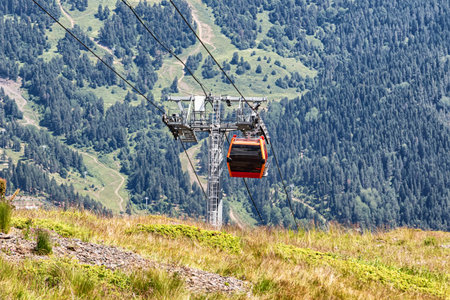 View of the cable car cabins that lift tourists to the mountain peak. Photo on the background of...