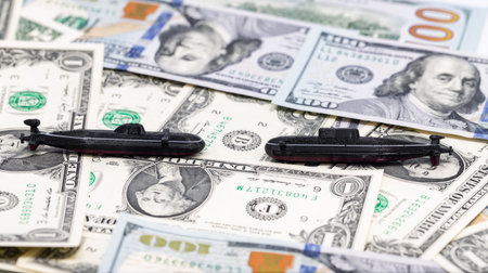 3D Printed Plastic Nuclear Submarine Machine Stands on Carpet of Dollar Billsの写真素材