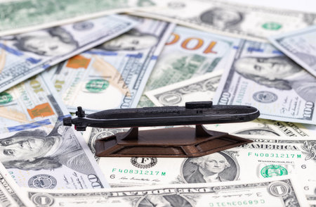 3D Printed Plastic Nuclear Submarine Machine Stands on Carpet of Dollar Billsの写真素材