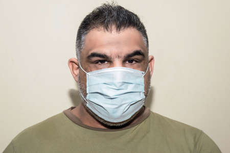 Latin fat man with gray beard wearing medical maskの写真素材