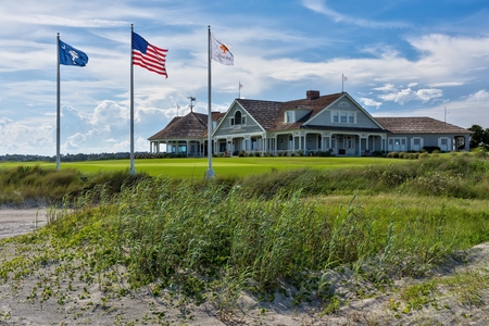 Kiawah Islands famous Ocean Course is iconic to golfers with the sand in the foreground, three flag poles along with the resort in background.