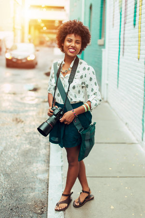 Dominican pretty girl taking pictures in City with sunset background, yellow and red light