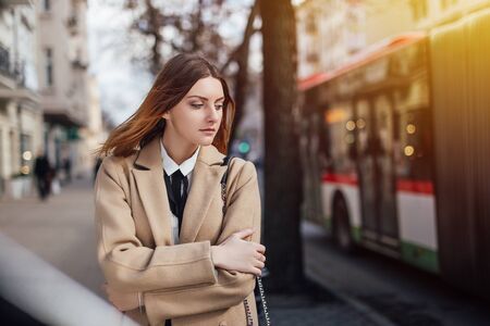 Girl standing on the street with sunset background wearing on glassesの写真素材