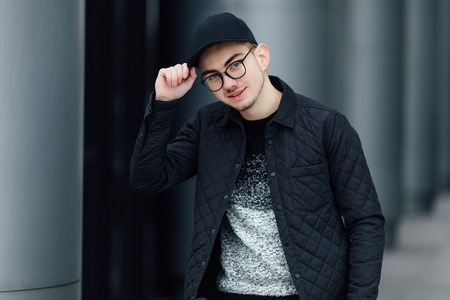 Fashionable man standing near wall with blur backgroundの写真素材