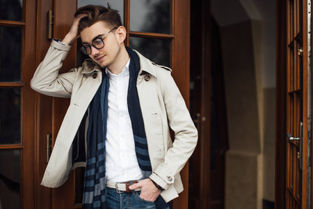 Fashionable man leaving working place, opening doorsの写真素材