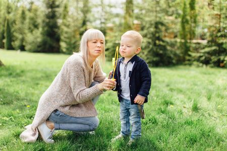 Little boy do bubbles with his mother at park backgroundの写真素材