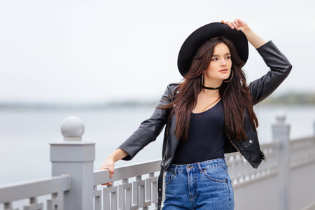 One girl stand on the street and hold her hatの写真素材