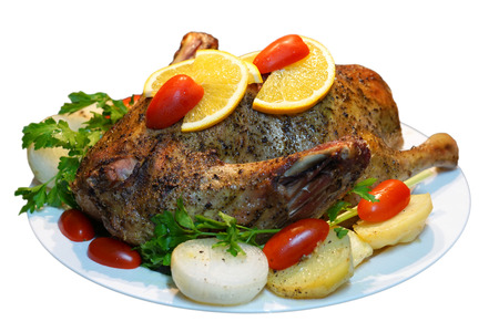 Christmas roast duck with potatoes, tomatoes and oranges isolated on whiteの写真素材