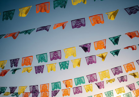 Colorful garland hanging on blue sky background. Decorated flags.の素材