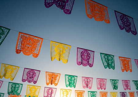 Colorful handkerchiefs hanging on clothesline against blue skyの素材