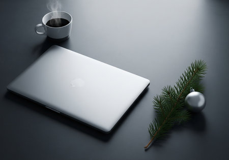 Laptop with cup of coffee and christmas tree on dark backgroundの素材
