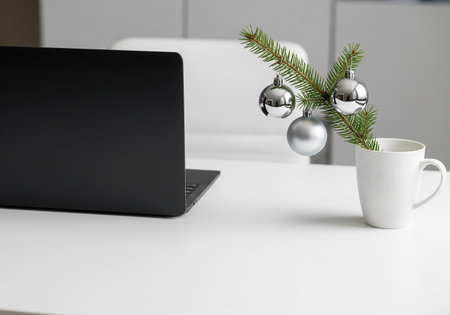 Laptop and coffee cup with christmas tree branch on white tableの素材