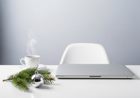 Laptop, cup of coffee and christmas decoration on white tableの素材