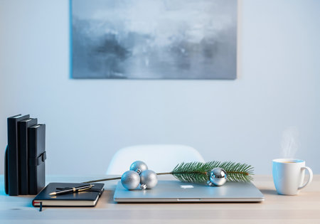 Laptop, coffee cup and christmas decorations on table in officeの素材